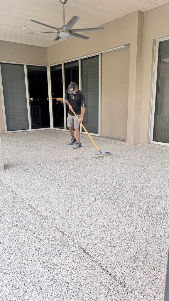 One of a Kind Epoxy installer rolling a topcoat on a Florida lanai